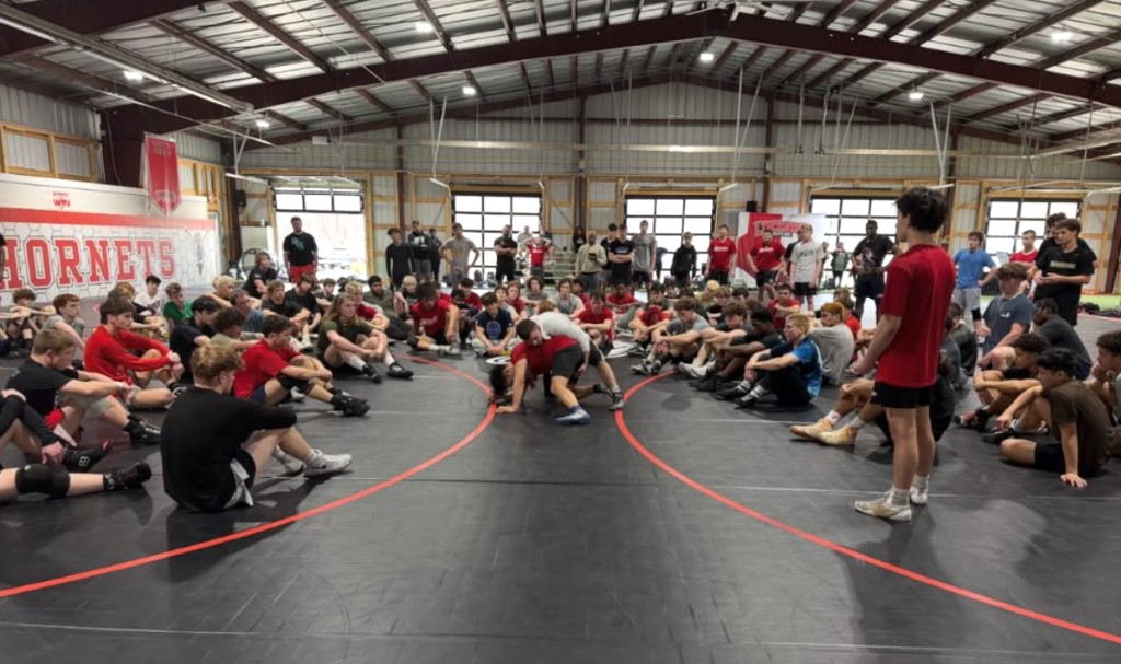 Prospect camp at Lynchburg’s wrestling facility: wrestlers in a circle on the mats for instruction, March