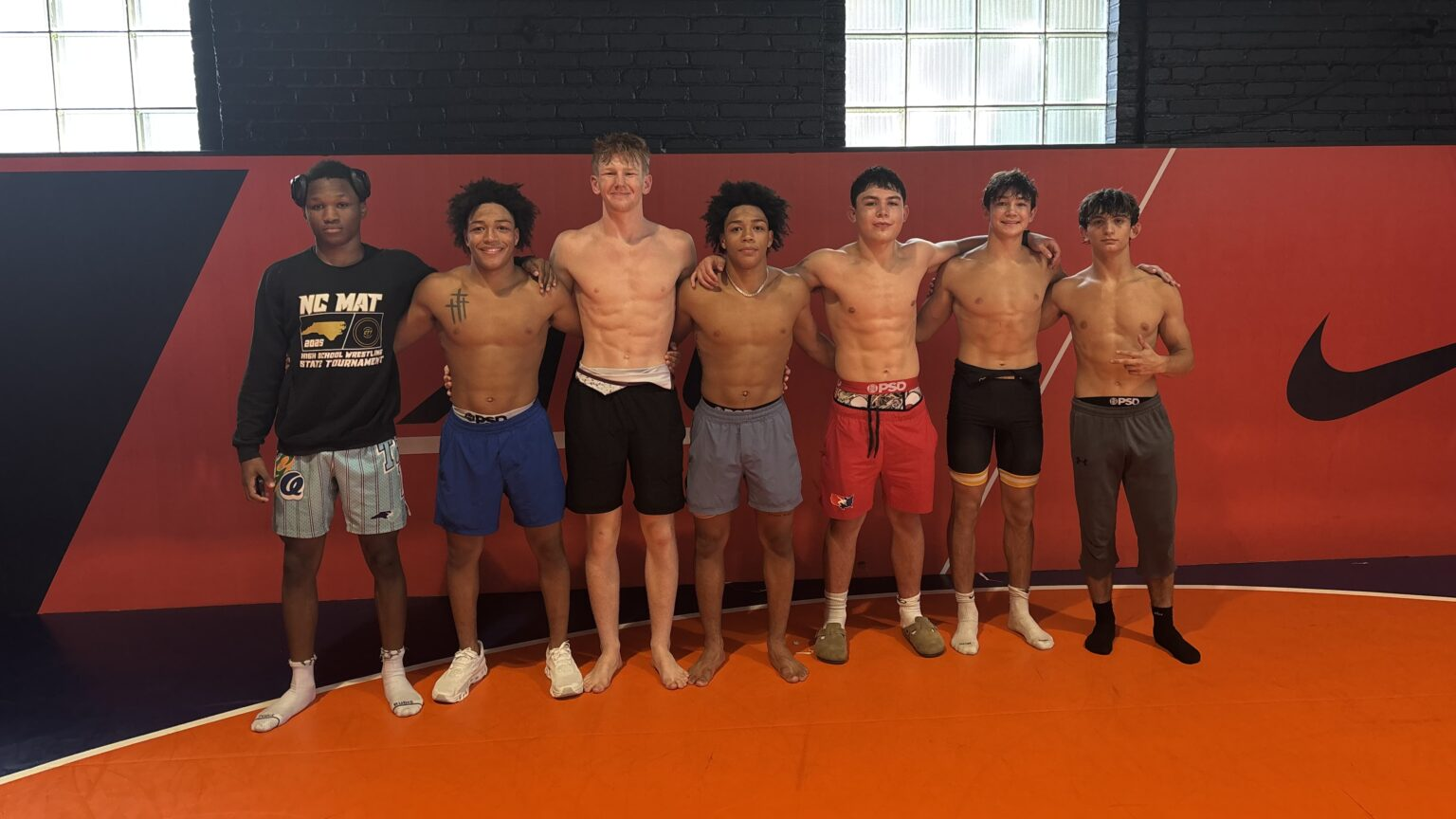 NC United Blue athletes standing together in the University of Virginia wrestling room